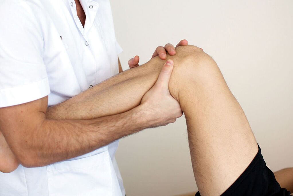 El doctor examina una rodilla con osteoartritis